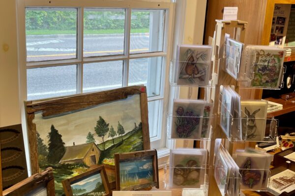 Museum shop display with paintings and postcards.