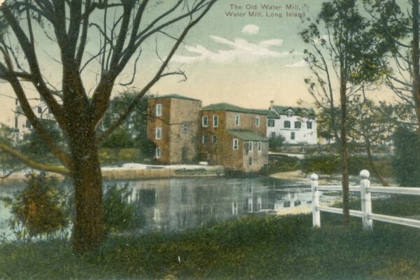 Old water mill by a tranquil pond.