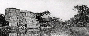 Historic riverside stone mill and wooden buildings
